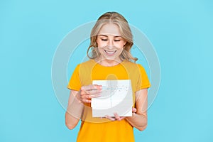 Smiling surprised woman holding wrapped gift box