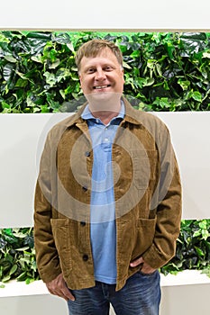 Smiling tall blond man in corduroy brown jacket