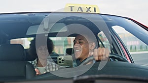 Smiling taxi driver talking with pretty lady during trip. Slow motion