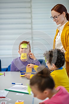 Smiling teacher helping pupils playing vocabulary game