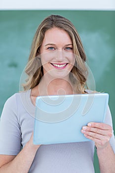 Smiling teacher holding tablet pc