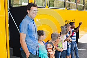 Smiling teacher and kids standing together