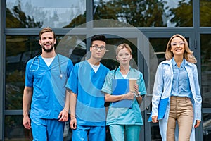 smiling teacher with multicultural students walking from