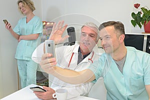 Smiling team doctors and nurses at hospital taking selfie