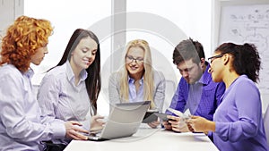 Smiling team with laptop and table pc computers