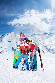 Smiling team with snowboards and skis