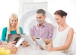 Smiling team with table pc and laptop in office