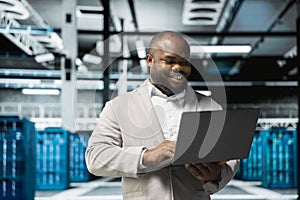 Smiling technician in data center workspace running system diagnostic tests