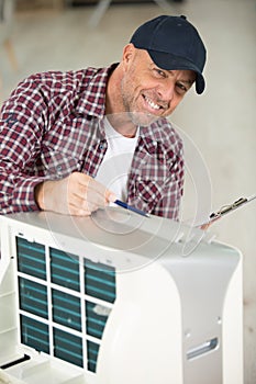 smiling technician repairing electric stove