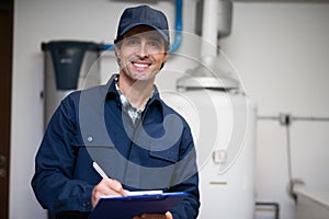 Smiling technician servicing an hot-water heater photo