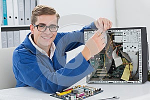 Smiling technician working on broken computer