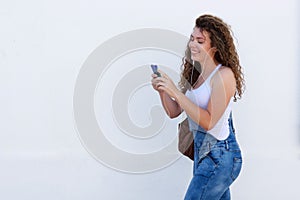 Smiling teen with cellphone and headphones walking