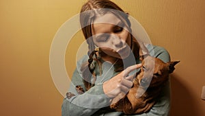 Smiling teen girl having fun with her little toy terrier doggy. 4K UHD.