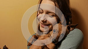Smiling teen girl having fun with her little toy terrier doggy. 4K UHD.