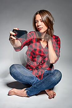 Smiling teen girl making self portrait on her smart phone