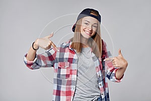 Smiling teen girl pointing at herself