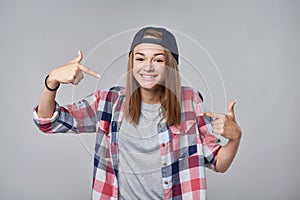 Smiling teen girl pointing at herself