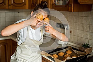 Smiling teen girl taking cookies out of the oven in the kitchen.Homemade cakes, cookies and gingerbread cookies. sweet