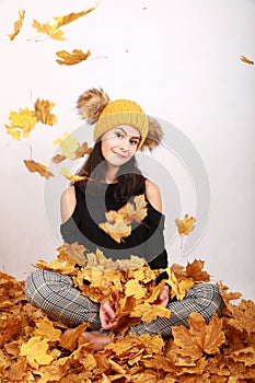 Smiling teen girl under falling dried leaves