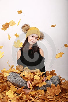 Smiling teen girl under falling dried leaves