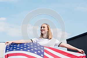 smiling teen girl with usa flag in front of