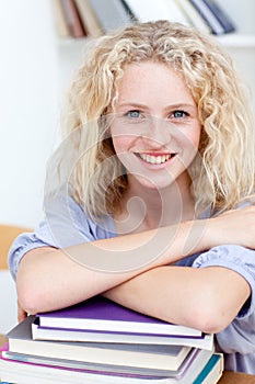 Smiling teen studying a lot of books