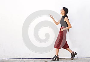 Smiling teen walking and looking at mobile phone