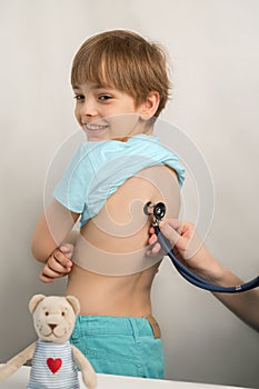 Smiling teenage boy at a doctor`s appointment at the clinic. The pediatrician Checking a child`s health