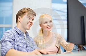 Smiling teenage boy and girl in computer class