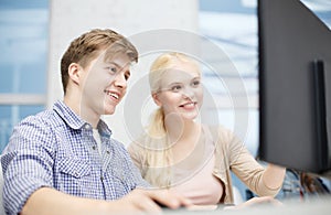 Smiling teenage boy and girl in computer class