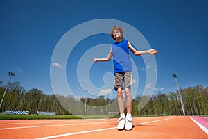 Smiling teenage boy jumping the rope outside