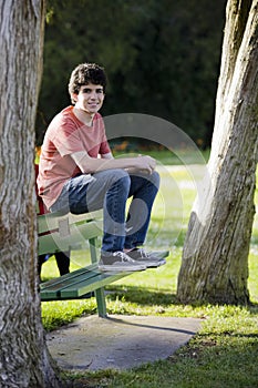 Smiling Teenage Boy Sitting on Bench