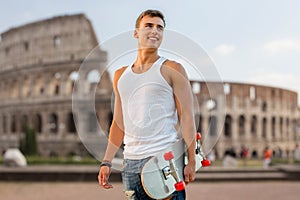 Smiling teenage boy with skateboard over coliseum