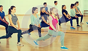 Smiling teenage boys and girls learning in dance hall