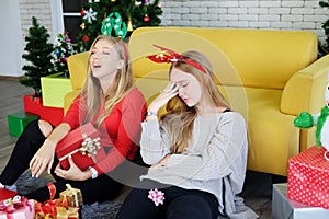 Smiling of Teenage. Caucasian couple girls is sitting on the floor. They Drunk and hangout for surprised with big Gift boxes in