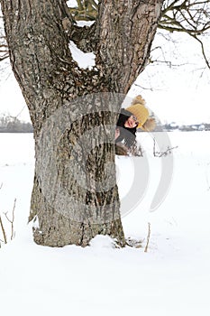 Smiling teenage girl behind tree