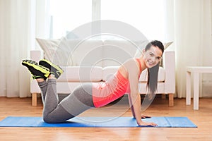 Smiling teenage girl doing push-ups at home