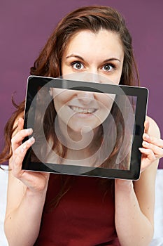 Smiling Teenage Girl Holding Digital Tablet In Front Of Face