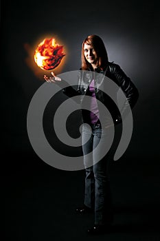 Smiling teenage girl holding orange fireball photo