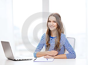 Smiling teenage girl laptop computer and notebook