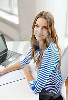 Smiling teenage girl laptop computer and notebook