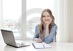 Smiling teenage girl laptop computer and notebook