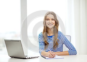 Smiling teenage girl laptop computer and notebook