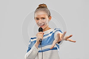 Smiling teenage girl with microphone singing