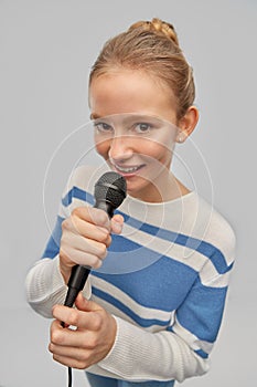 Smiling teenage girl with microphone singing