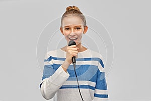 Smiling teenage girl with microphone singing