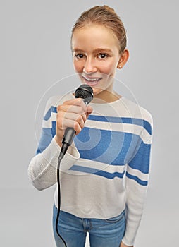 Smiling teenage girl with microphone singing