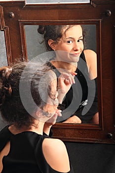 Smiling teenage girl in night dress mirroring in mirror