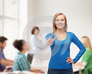 Smiling teenage girl showing v-sign with hand