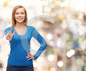 Smiling teenage girl showing v-sign with hand